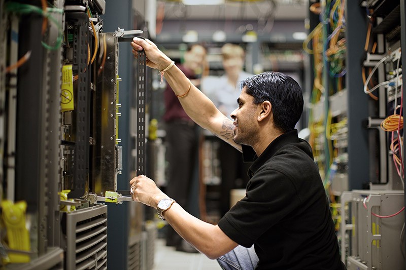IT admin installing rack mountable server in data center