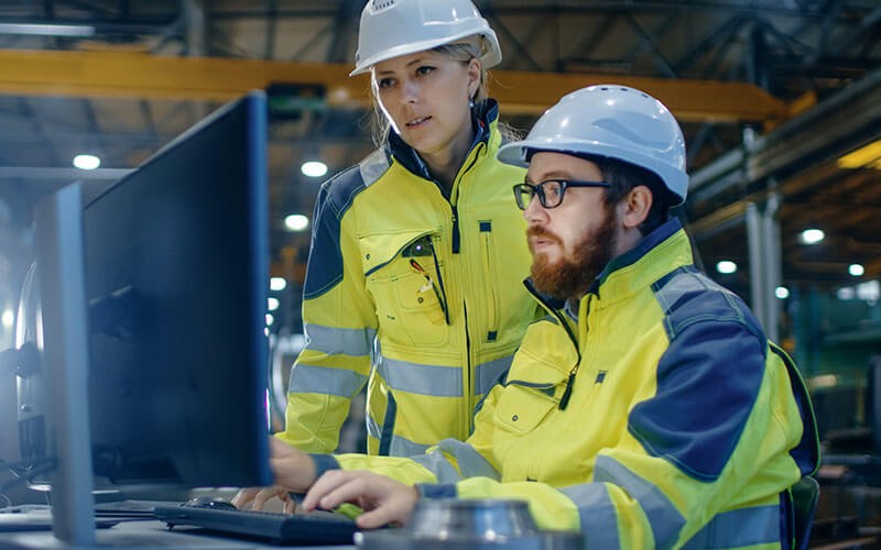 Two employees working on computer in warehouse