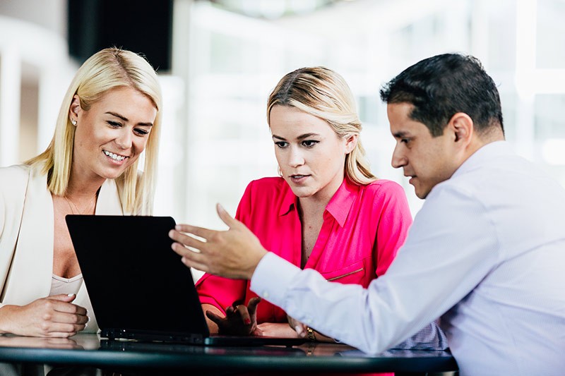 Team meeting around a notebook computer